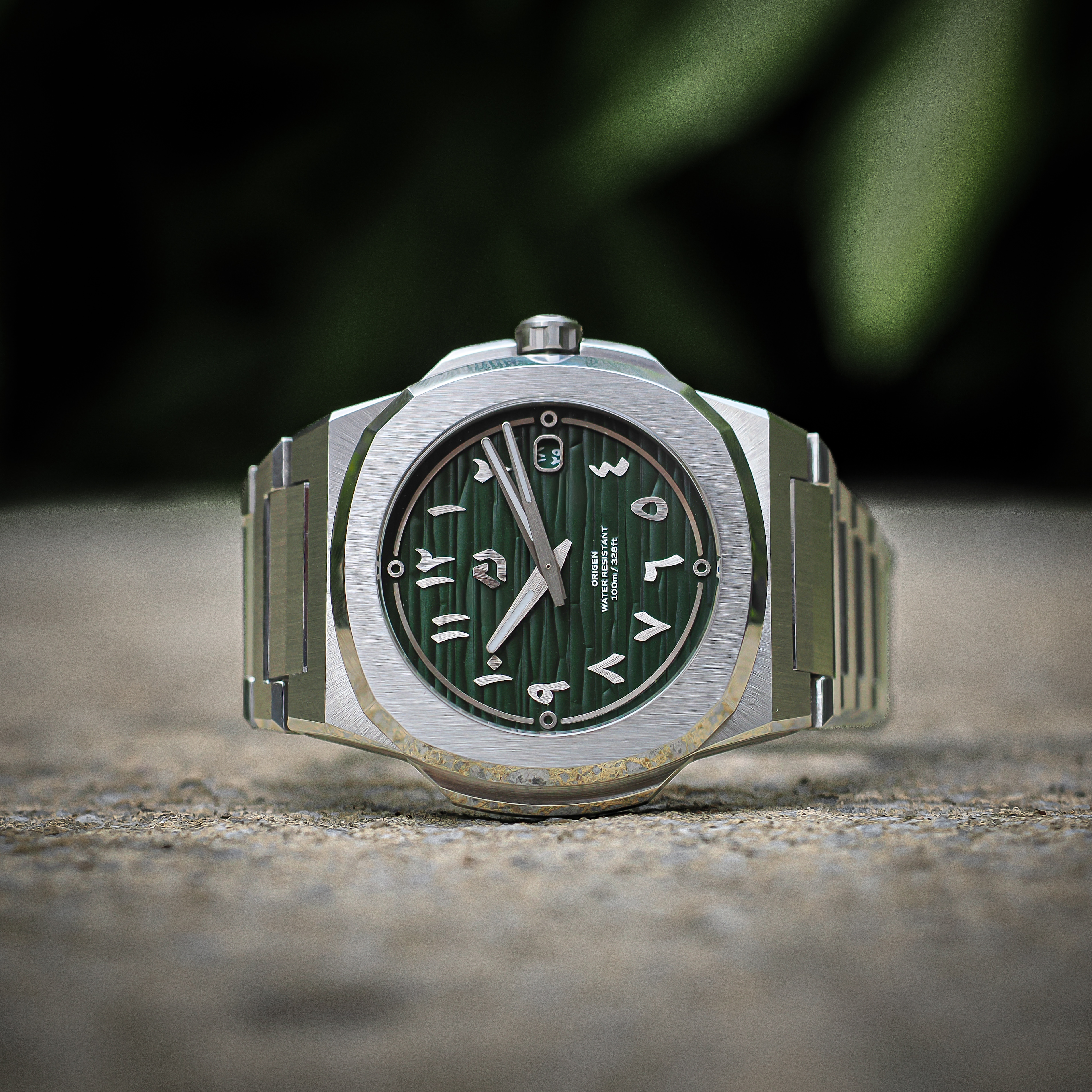 Nuncier Origen green dial watch photographed outdoors on stone