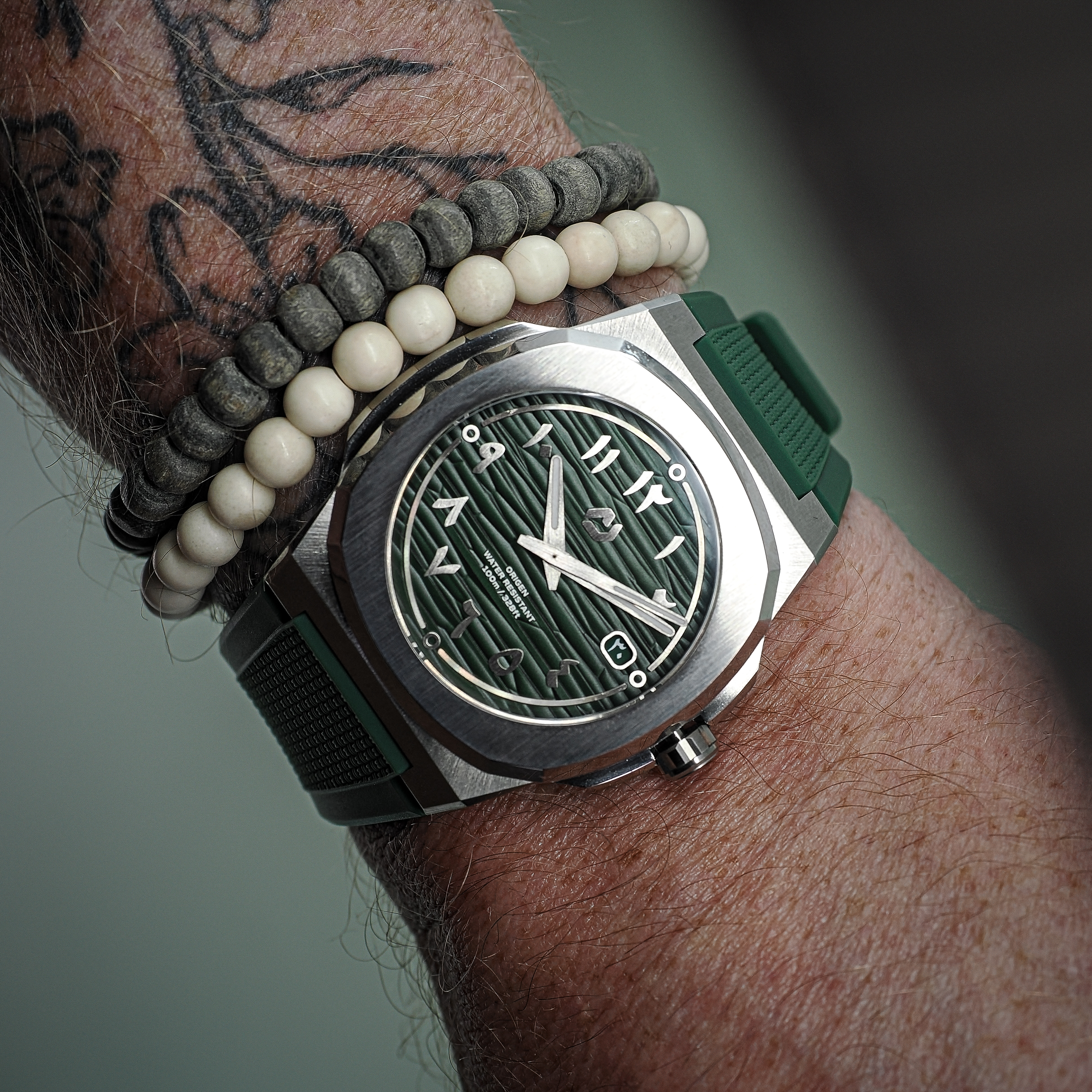 Nuncier Origen green dial watch worn on a matching green rubber strap